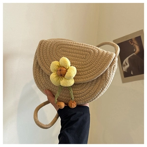 Detail of hand-woven shell bag with a large yellow sunflower and thin braided strap