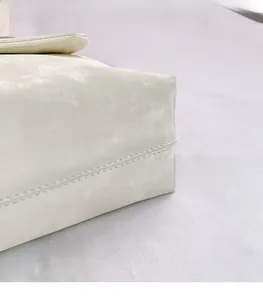 Detail shot of beige shoulder bag showing high-quality fabric texture and fine stitching
