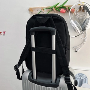 Détail de la sangle pour bagages sur un sac à dos noir minimaliste pour le voyage