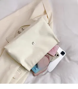 Internal view of large beige shoulder bag showing capacity for phone and tablet