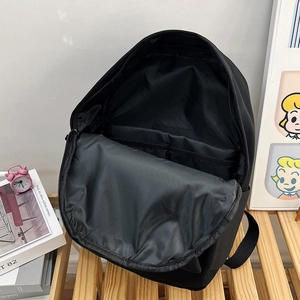 Vue détaillée de l'intérieur du sac à dos noir montrant le compartiment principal spacieux
