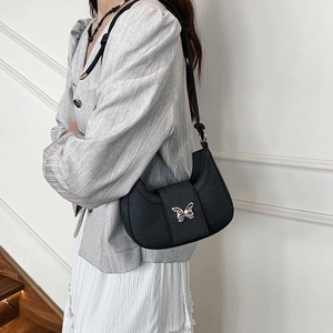 Sac sous le bras demi-lune noir minimaliste avec boucle papillon argentée pour femme