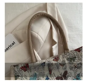 Detail showing the sturdy woven rope handle and colorful butterfly pattern on the tote bag