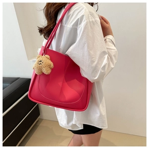 Detailed side view of a large magenta tote bag with a cute brown teddy bear keychain