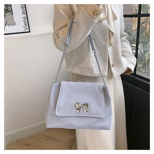 Detail of lavender shoulder bag with silver bow buckle and elegant metal chain strap
