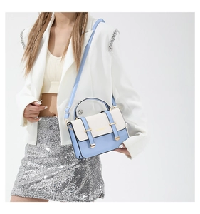 Vue détaillée d'un sac bandoulière bicolore en cuir PU avec détails dorés en forme de cœur