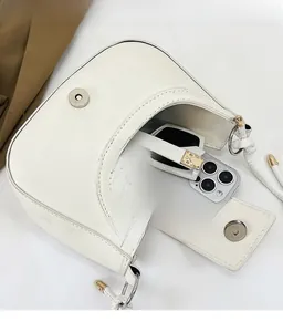 Détail de l'intérieur d'un sac porté épaule en cuir blanc avec un grand espace de rangement