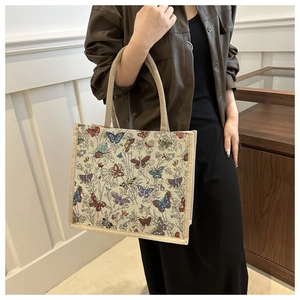 Detail of vintage tote bag featuring colorful butterfly prints and woven texture
