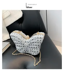 Detailed macro view of a silver sequined butterfly-shaped clutch with gold metal frame