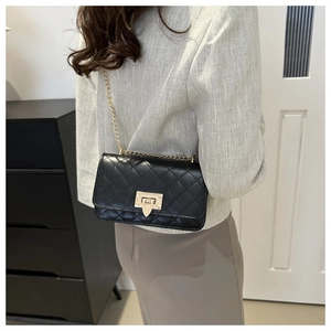 Détail d'un sac à chaîne matelassé noir avec fermoir doré et coutures de haute qualité