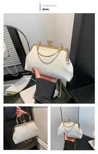 Macro view of white satin evening bag with vintage gold carved metal frame and pearl clasp