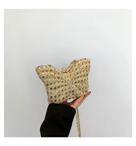 Close-up of butterfly sequin evening bag featuring a spherical diamond clasp and gold chain
