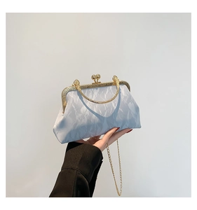 Detail of light blue pleated handbag with vintage gold metal frame and kiss-lock closure