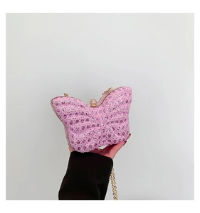 Detail of butterfly-shaped clutch bag featuring pink crystals and golden chain strap