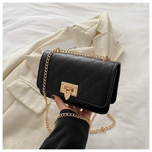 Détail du sac bandoulière matelassé noir avec chaîne dorée et fermoir métallique carré