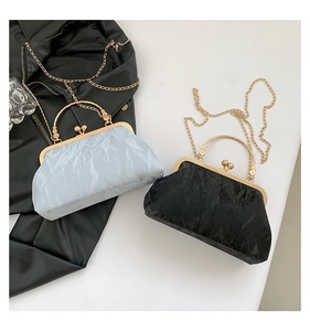 Detail of elegant pleated textures and metallic frame clasp on chic shoulder handbags
