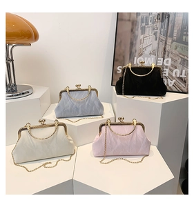 Macro shot of stylish pleated evening bags in four colors with gold kiss-lock metal frames