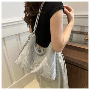 Dettaglio della borsa hobo argento metallizzato con farfalla e tracolla a catena