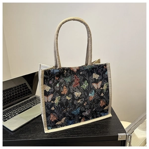 Close-up detail of vintage floral tote bag showing colorful butterfly embroidery texture