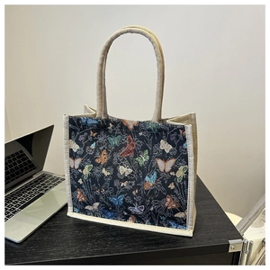 Detailed macro view of vintage tapestry handbag with colorful woven butterfly patterns