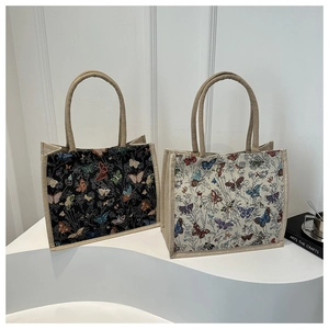 Detail of vintage tote bags with colorful butterfly and floral prints on canvas material