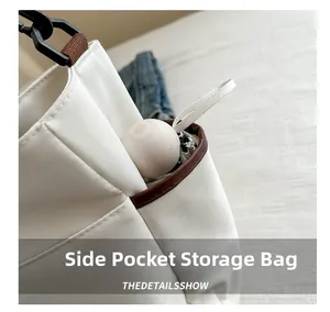 Close-up of functional side storage pocket on canvas tote bag holding a folding umbrella