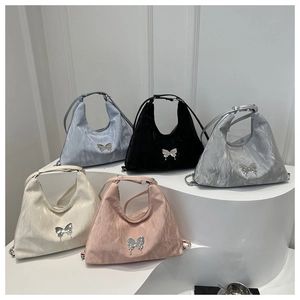 Dettaglio di cinque borse Hobo in vari colori con farfalla metallica e pendente fluido