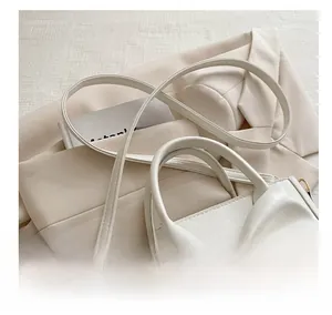 Detailed macro shot of white leather bag featuring bow detail and gold hardware links