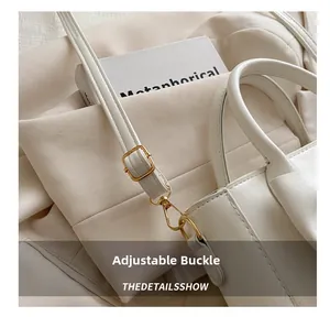 Close-up of adjustable strap with gold buckles on a beige minimalist handbag