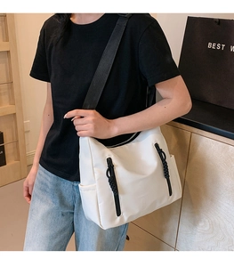 Détail du grand sac cabas blanc en nylon avec fermetures noires et bandoulière tissée