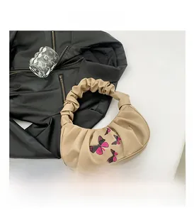 Detail showing khaki ruched cloud bag with purple butterfly print and soft PU texture