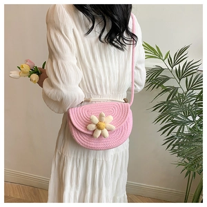 Detail of pink woven cotton shoulder bag with a 3D daisy flower and rope strap