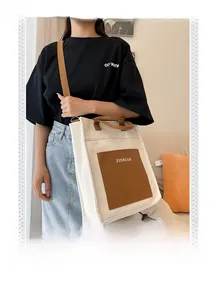 Detail of color-block canvas tote bag with brown leather pocket and adjustable strap