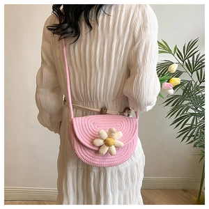 Detail of pink hand-woven cotton shoulder bag with a white 3D daisy flower charm