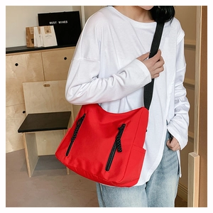 Détail du grand sac cabas rouge en nylon avec fermetures éclair et poches latérales
