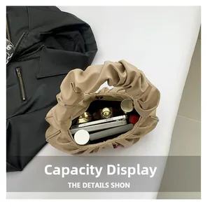 Interior view of beige ruched cloud bag showing capacity for phone and cosmetics