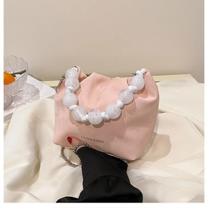 Dettaglio borsa nuvola a pieghe rosa con manico in perle effetto marmo e logo