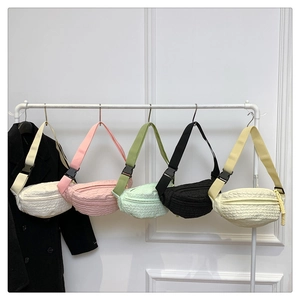 Detailed macro view of five textured crossbody chest bags in various pastel colors