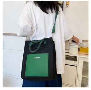 Detail of minimalist canvas tote bag with black and green color blocking design