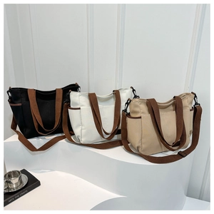 Three canvas tote bags in black, white, and beige with brown straps for daily use