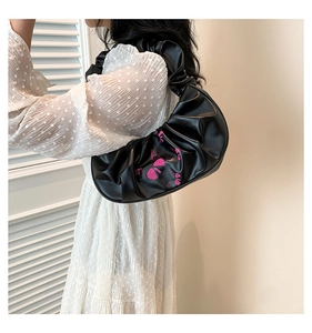 Side view of pleated black croissant bag with pink butterfly print and scrunchie strap