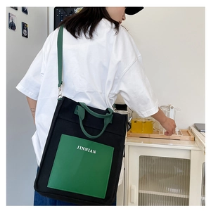 Detail of canvas tote bag with green pocket and adjustable shoulder strap for daily use