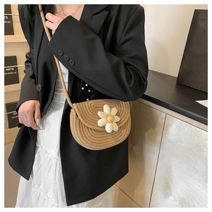 Detailed macro view of handmade woven straw crossbody bag with 3D daisy flower and smiley face