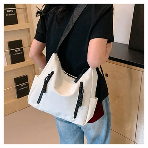 Détail du sac fourre-tout en nylon blanc avec zips noirs et décoration en corde tressée
