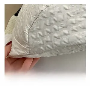 Close-up of precise stitching and unique textured fabric on this white fashion crossbody bag