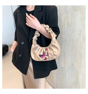 Detail view of beige ruched crescent bag featuring exquisite pink and purple butterfly embroidery