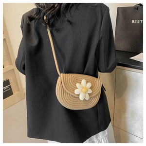 Detail of hand-woven cotton rope shoulder bag featuring a white daisy floral accent