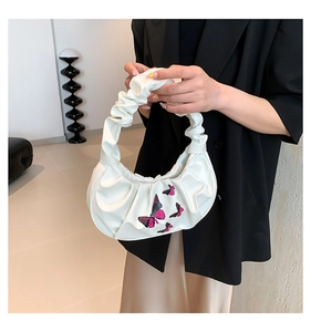 Close-up of a white cloud bag with pink and black butterfly embroidery and pleats