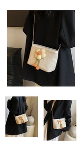 Détail du sac seau en paille tressée beige avec fleur et chaîne dorée