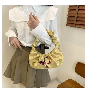 Detail of champagne gold cloud bag with butterfly embroidery and ruffled handle